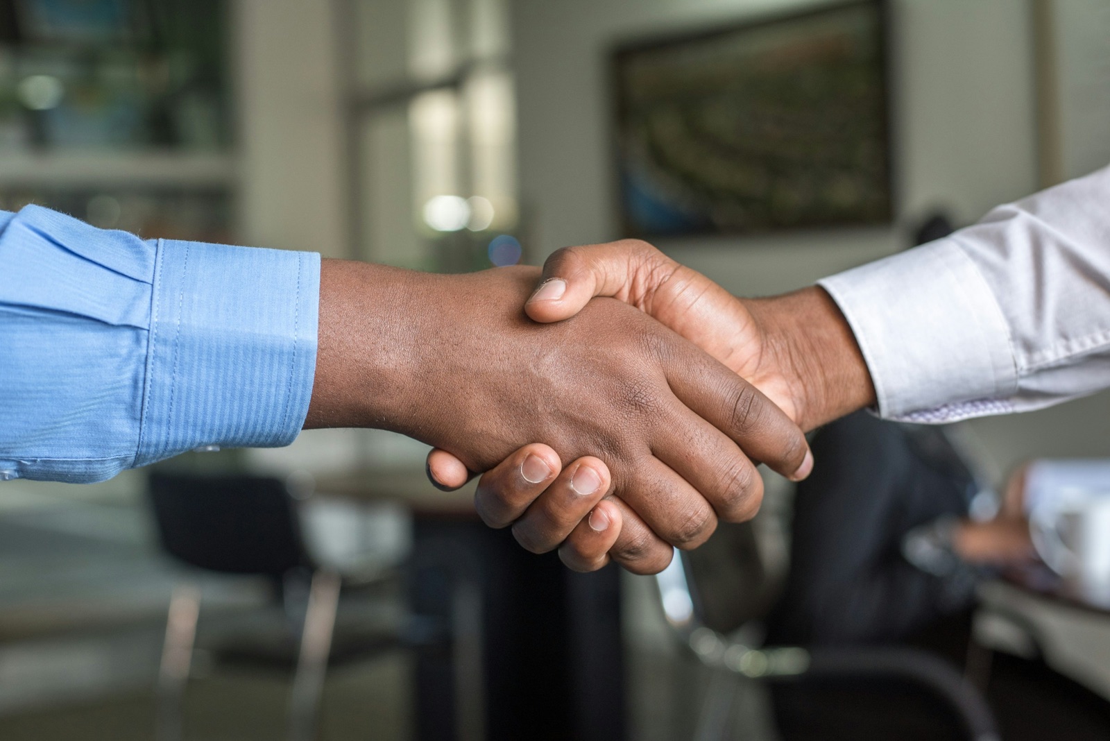 Two people shaking hands in an office setting