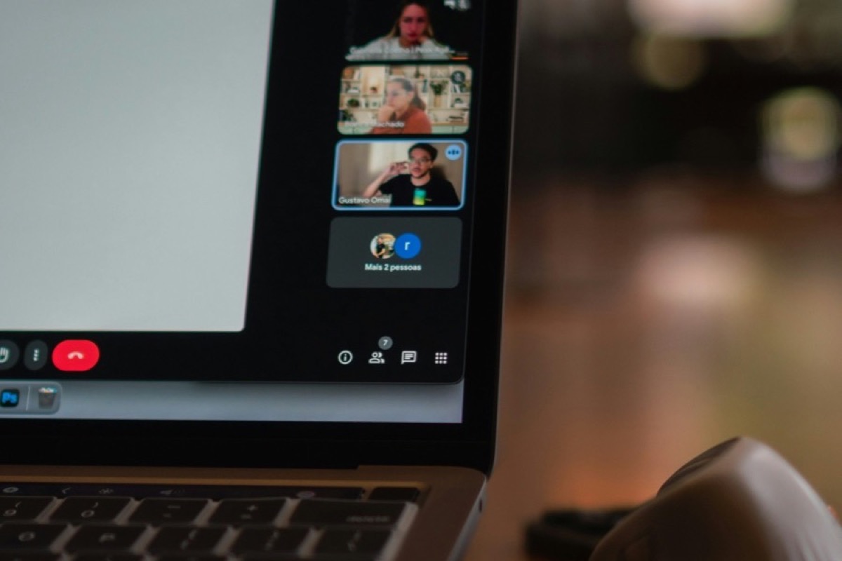 A laptop screen showing a video call with multiple participants